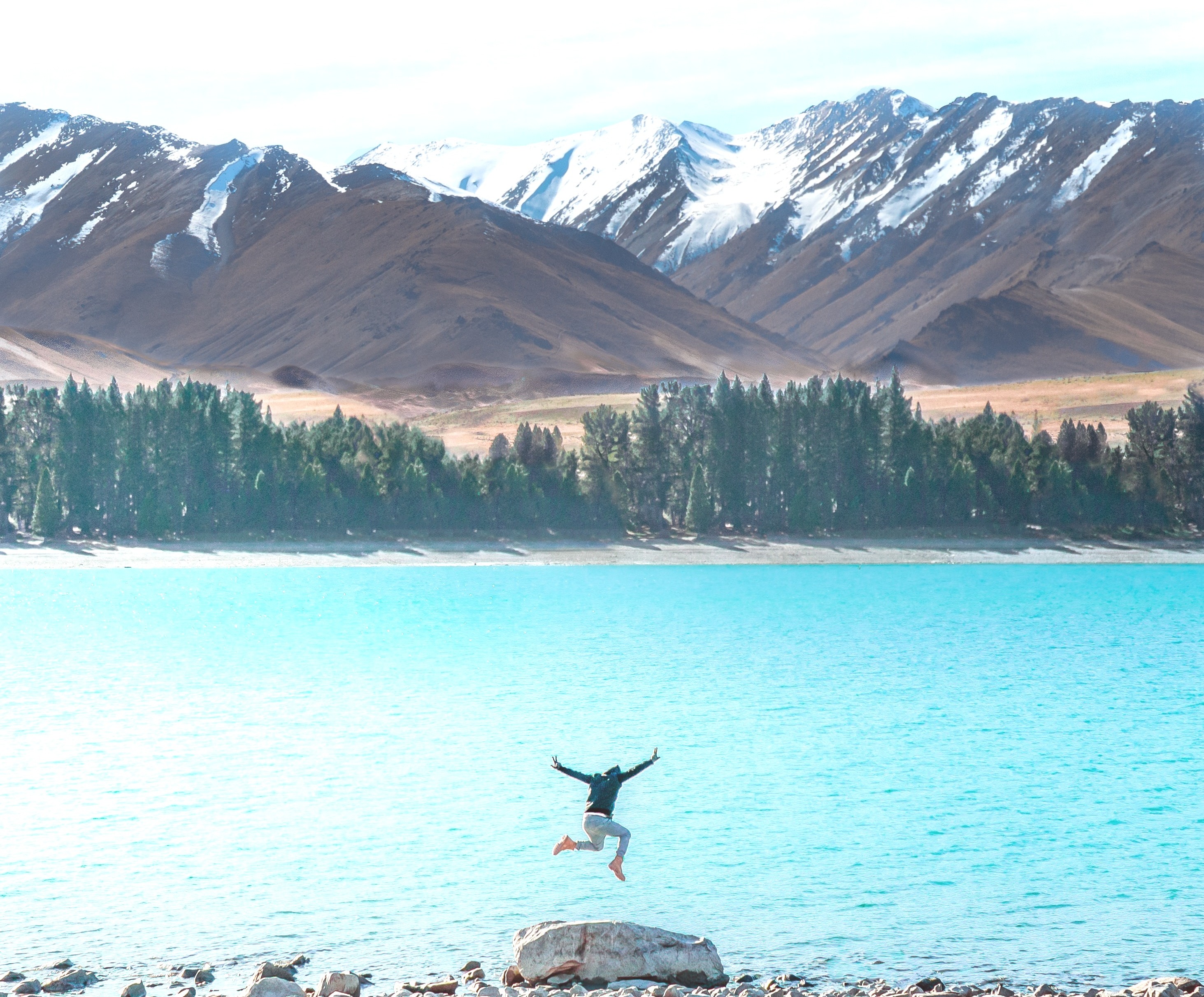 man jumping into lake full clothing